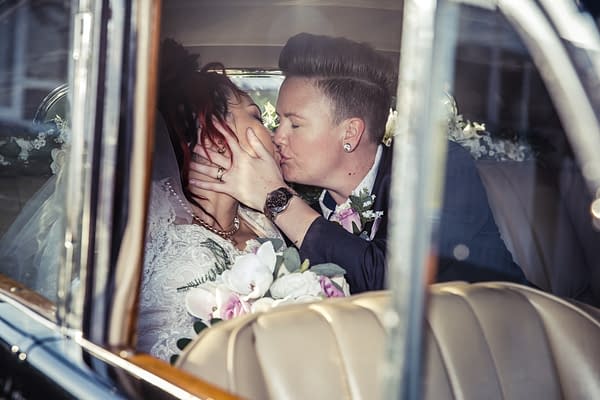 Same-sex-wedding-couple-kissing-in-an-old-vintage-car